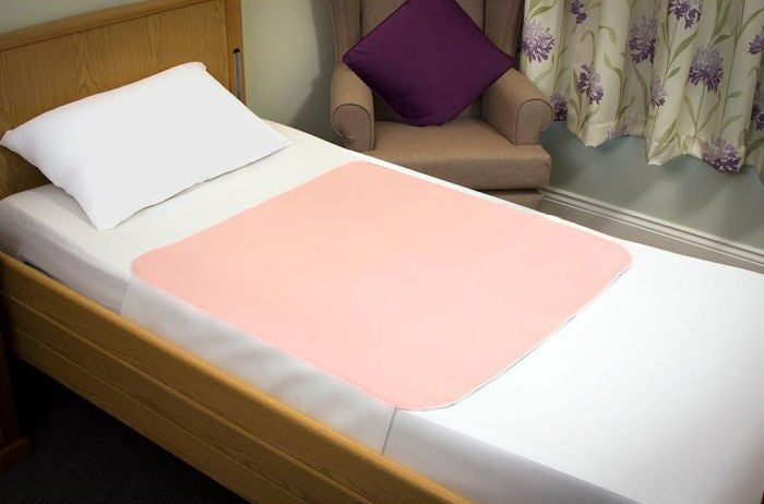 Pink Sonoma Bedpad displayed on bed.